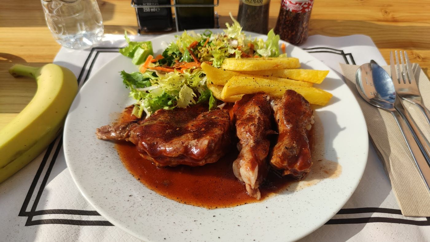 Plato de solomillo de cerdo con salsa especial, patatas fritas y ensalada fresca.
